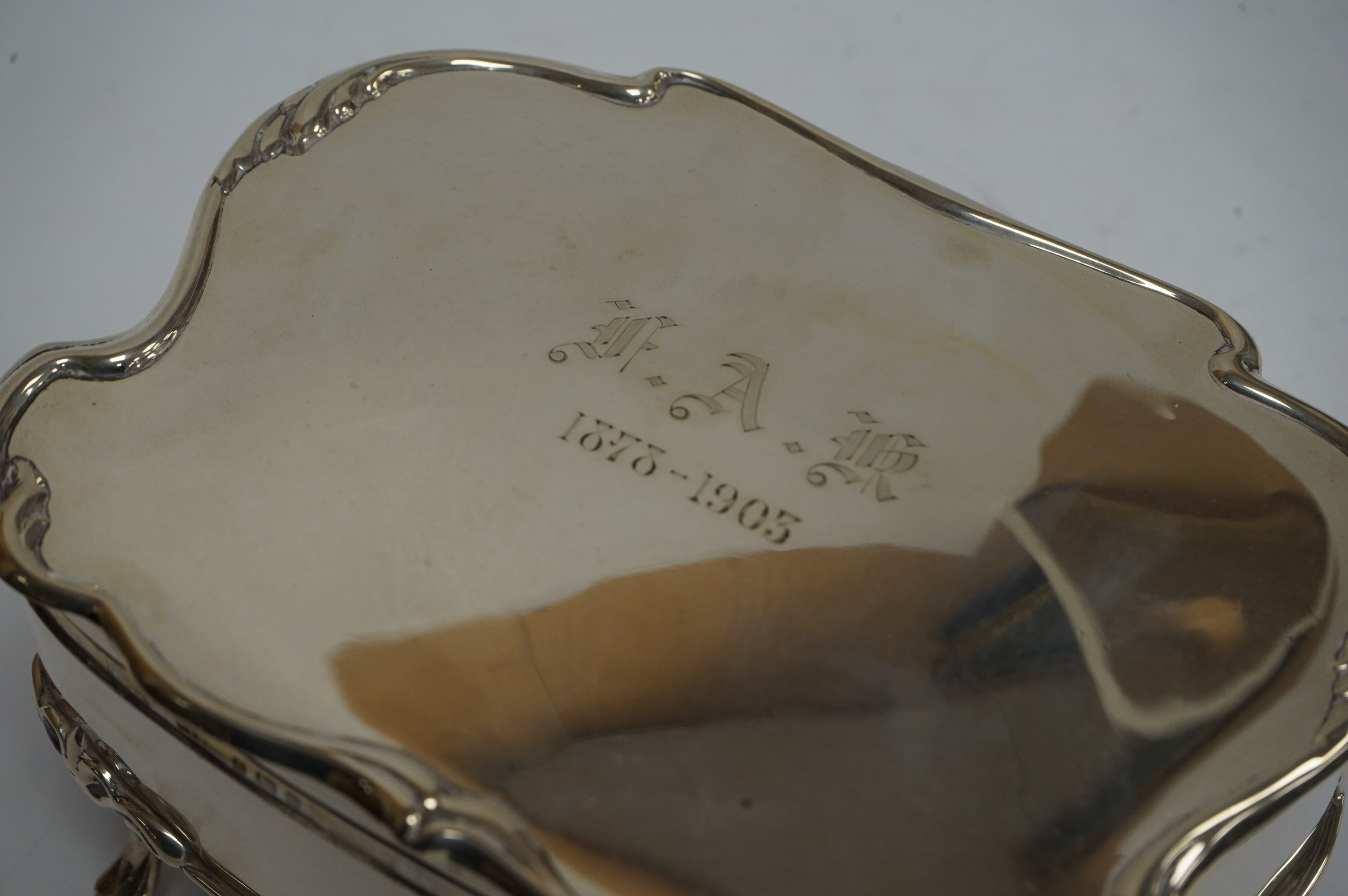 An Edwardian silver shaped rectangular trinket box, with engraved initials and date, on four cabriole legs, Saunders & Shepherd, Birmingham, 1902, (lacking interior), width 16.7cm, 13.2oz. Condition - fair